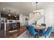 Open dining area features a round table with blue upholstered chairs and a decorative light fixture at 12659 Stone Creek Ct, Firestone, CO 80504