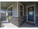 Inviting covered front porch with a stone facade and beautiful wood trim at 12659 Stone Creek Ct, Firestone, CO 80504