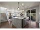Modern kitchen with island sink, stainless appliances, dining room view, and access to backyard patio at 12659 Stone Creek Ct, Firestone, CO 80504