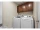 Convenient laundry room with modern washer and dryer and overhead cabinets at 12659 Stone Creek Ct, Firestone, CO 80504