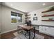 Well-lit office space with wood floors, custom shelves, and a large window at 12659 Stone Creek Ct, Firestone, CO 80504