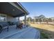 Covered patio overlooking a fenced yard, with seating, grill, and green lawn at 12659 Stone Creek Ct, Firestone, CO 80504