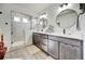 Bright primary bathroom offers a double vanity, large mirrors, and a glass-enclosed shower at 26293 E Archer Ave, Aurora, CO 80018