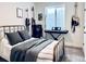 Bedroom with natural light, guitar decor and a bed featuring stylish grey pillows and blanket at 26293 E Archer Ave, Aurora, CO 80018