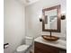 Stylish powder room with vessel sink, marble countertop, wood mirror, and modern fixtures at 5454 S Everett Ct, Littleton, CO 80123