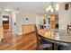 Open dining area with hardwood floors flowing into the kitchen featuring wooden cabinets and granite countertops at 5454 S Everett Ct, Littleton, CO 80123