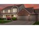 Charming two-story home with a well-manicured lawn, brick accents, and a three-car garage during sunset at 5454 S Everett Ct, Littleton, CO 80123
