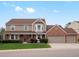 Charming two-story home with a well-manicured lawn, brick accents, and a three-car garage at 5454 S Everett Ct, Littleton, CO 80123