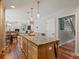 Open kitchen with oversized island, wood cabinets, granite counters and leads into living area at 5454 S Everett Ct, Littleton, CO 80123