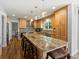 Charming kitchen features an island with seating, wood cabinets, granite counters and pendant lighting at 5454 S Everett Ct, Littleton, CO 80123