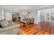 Spacious living room with hardwood floors, comfortable leather seating, and easy access to the dining room and entryway at 5454 S Everett Ct, Littleton, CO 80123