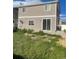 View of the home and backyard showing overgrown grass and an exterior air conditioning unit at 5537 Malta St, Denver, CO 80249