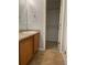 Bathroom featuring a vanity, large mirror, tiled floor and access to closet at 5537 Malta St, Denver, CO 80249