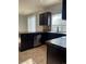 Kitchen area with stainless steel appliances and dark cabinets in a modern space at 5537 Malta St, Denver, CO 80249