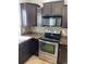 Kitchen with dark cabinets, stainless steel oven, and mosaic backsplash at 5537 Malta St, Denver, CO 80249