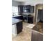 Kitchen featuring stainless steel appliances, dark cabinetry, and ample counter space at 5537 Malta St, Denver, CO 80249