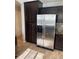 Kitchen with dark cabinetry and stainless steel refrigerator at 5537 Malta St, Denver, CO 80249
