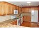 Bright kitchen featuring light wood cabinetry, granite countertops, and modern white appliances at 6150 W Mansfield Ave # 33, Denver, CO 80235