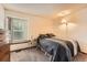 Cozy bedroom features natural light from the window and neutral tones at 4162 S Dunkirk Way, Aurora, CO 80013