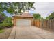 Detached garage with a white door and spacious concrete driveway at 4162 S Dunkirk Way, Aurora, CO 80013