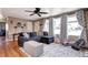Inviting living room features a comfortable sectional sofa, large windows with patterned curtains, and beautiful hardwood floors at 835 Lewis Dr, Lakewood, CO 80215