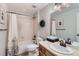 Bright bathroom featuring a shower-tub combination with white tiling, a large mirror, and neutral wall color at 3386 Beeler Ct, Denver, CO 80238