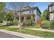 Attractive two-story home with a covered front porch, complemented by mature trees and established landscaping at 3386 Beeler Ct, Denver, CO 80238