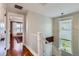 Bright hallway with wood floors, a white staircase, and a view into another room at 3386 Beeler Ct, Denver, CO 80238