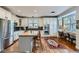 Bright kitchen with white cabinets, stainless appliances, island with seating, and adjacent dining area at 3386 Beeler Ct, Denver, CO 80238