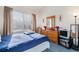 Bright bedroom with a dresser, comfy bed, soft natural light from the window, and neutral-toned walls at 1079 S Walden Way # 217, Aurora, CO 80017