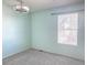 A bright bedroom with gray carpet, modern fan, and a window with natural light at 15475 E Louisiana Ave, Aurora, CO 80017