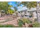 Beautifully landscaped backyard with a stone patio, outdoor seating, and lush greenery, ideal for relaxing or entertaining at 87 Prairie Ridge Rd, Highlands Ranch, CO 80126