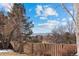 Scenic backyard view with a privacy fence and mature trees, offering a peaceful and secluded outdoor space at 87 Prairie Ridge Rd, Highlands Ranch, CO 80126