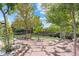 Expansive backyard with a stone patio, hammock, and lush trees, offering ample space for recreation and relaxation at 87 Prairie Ridge Rd, Highlands Ranch, CO 80126