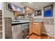 Basement wet bar includes mini refrigerator, wood cabinets, and decorative tile backsplash at 87 Prairie Ridge Rd, Highlands Ranch, CO 80126