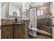 Stylishly renovated bathroom showcasing stone backsplash, wooden vanity, and tiled shower at 87 Prairie Ridge Rd, Highlands Ranch, CO 80126