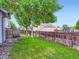 Large backyard featuring a deck, mature trees, lush green grass and wooden fencing around the perimeter at 12646 Osceola St, Broomfield, CO 80020