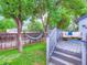Large backyard with mature trees offering shade, a wooden fence surrounding and a deck for relaxing and entertaining at 12646 Osceola St, Broomfield, CO 80020