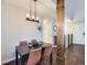 Inviting dining room boasts a modern light fixture, wood floors, and an exposed structural wood column at 12646 Osceola St, Broomfield, CO 80020