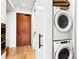 Convenient laundry area with stacked washer and dryer, maximizing space and efficiency, nestled near a modern wooden door at 1901 Wazee St # 419, Denver, CO 80202