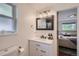 Bathroom with white vanity and a gray framed mirror, with a view into the primary bedroom at 7746 S Gray St, Littleton, CO 80128