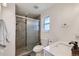 Bathroom features a shower with glass sliding door, toilet, vanity with a marble countertop, and a window at 7746 S Gray St, Littleton, CO 80128