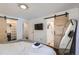 Bedroom featuring hardwood floors, barn doors, and a walk-in closet and an ensuite bathroom at 7746 S Gray St, Littleton, CO 80128