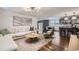 Open-concept living room with modern lighting, hardwood floors, and seamlessly connected to the dining and kitchen areas at 7746 S Gray St, Littleton, CO 80128