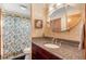 Bathroom showcasing granite counters, tiled backsplash, oval mirror, and shower with leafy curtain at 3620 Silver Plume Ln, Boulder, CO 80305