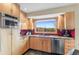Bright kitchen boasts wooden cabinets, stainless steel appliances, and a picturesque window view at 3620 Silver Plume Ln, Boulder, CO 80305