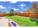 Lush backyard features a well-manicured lawn, landscaping, fencing, and a fire pit at 25262 E 2Nd Pl, Aurora, CO 80018