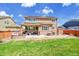 Expansive backyard showcasing a covered patio, seating, lush lawn, and solar panels above at 25262 E 2Nd Pl, Aurora, CO 80018