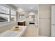 Bright bathroom featuring a soaking tub with shutters and a peek into the bedroom at 25262 E 2Nd Pl, Aurora, CO 80018