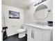 Modern bathroom with a beautiful round mirror, white cabinets and black tile floor at 25262 E 2Nd Pl, Aurora, CO 80018